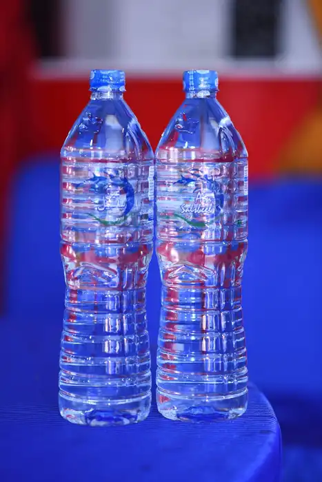 Two plastic water bottles stand on a blue table.