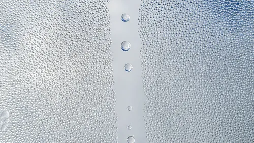 Close-up of water droplets scattered across a glass pane.