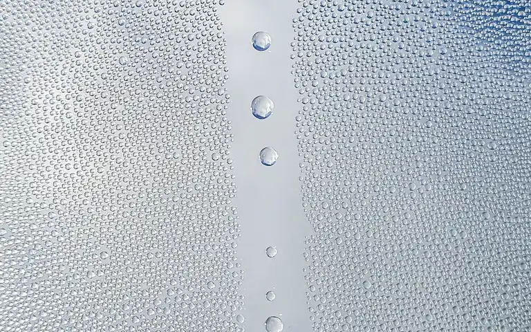 Close-up of water droplets scattered across a glass pane.
