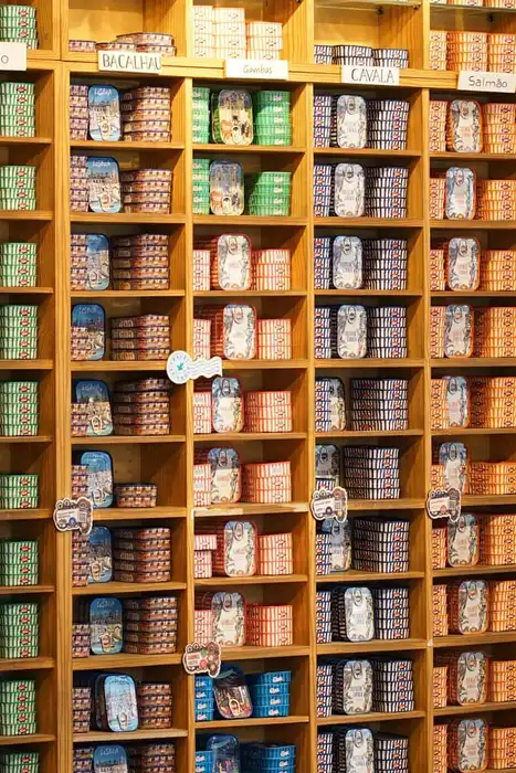 Assorted canned goods are arranged on store shelves.