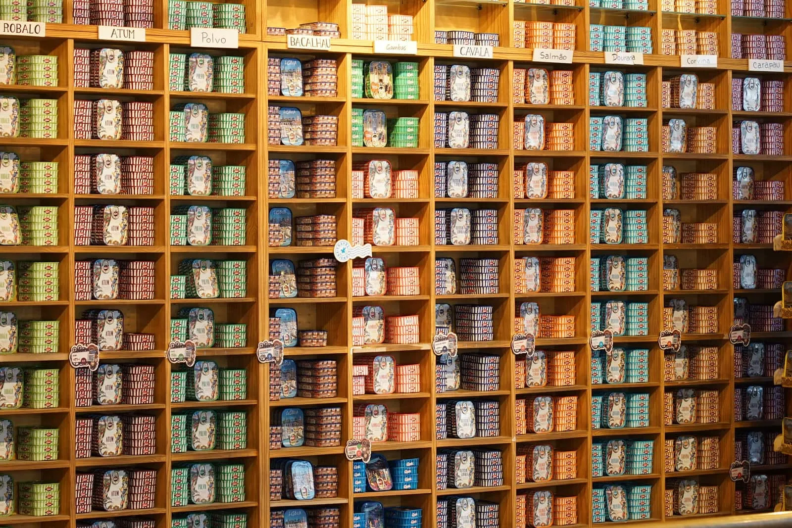 Assorted canned goods are arranged on store shelves.