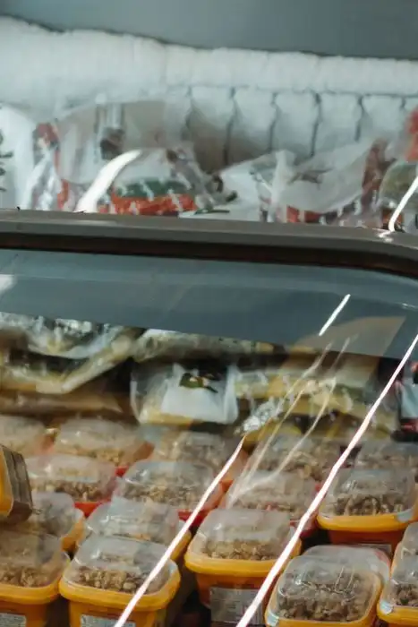 Packaged frozen foods are displayed in a commercial chest freezer.