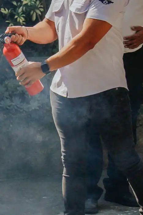 Two men demonstrate a fire extinguisher outdoors