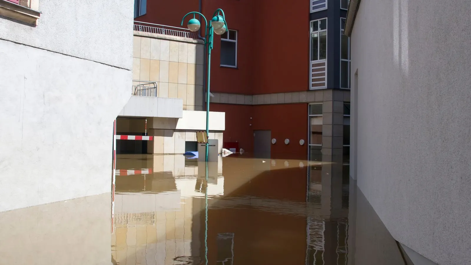 Floodwater standing between residential buildings on an urban street