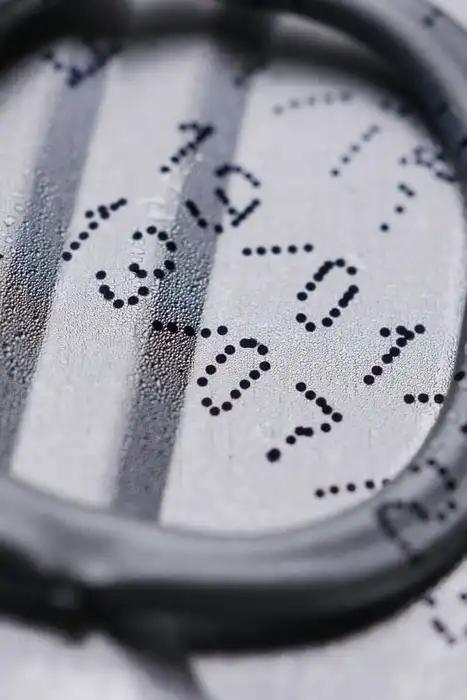 Close-up of a drink-can lid with a printed expiration date.