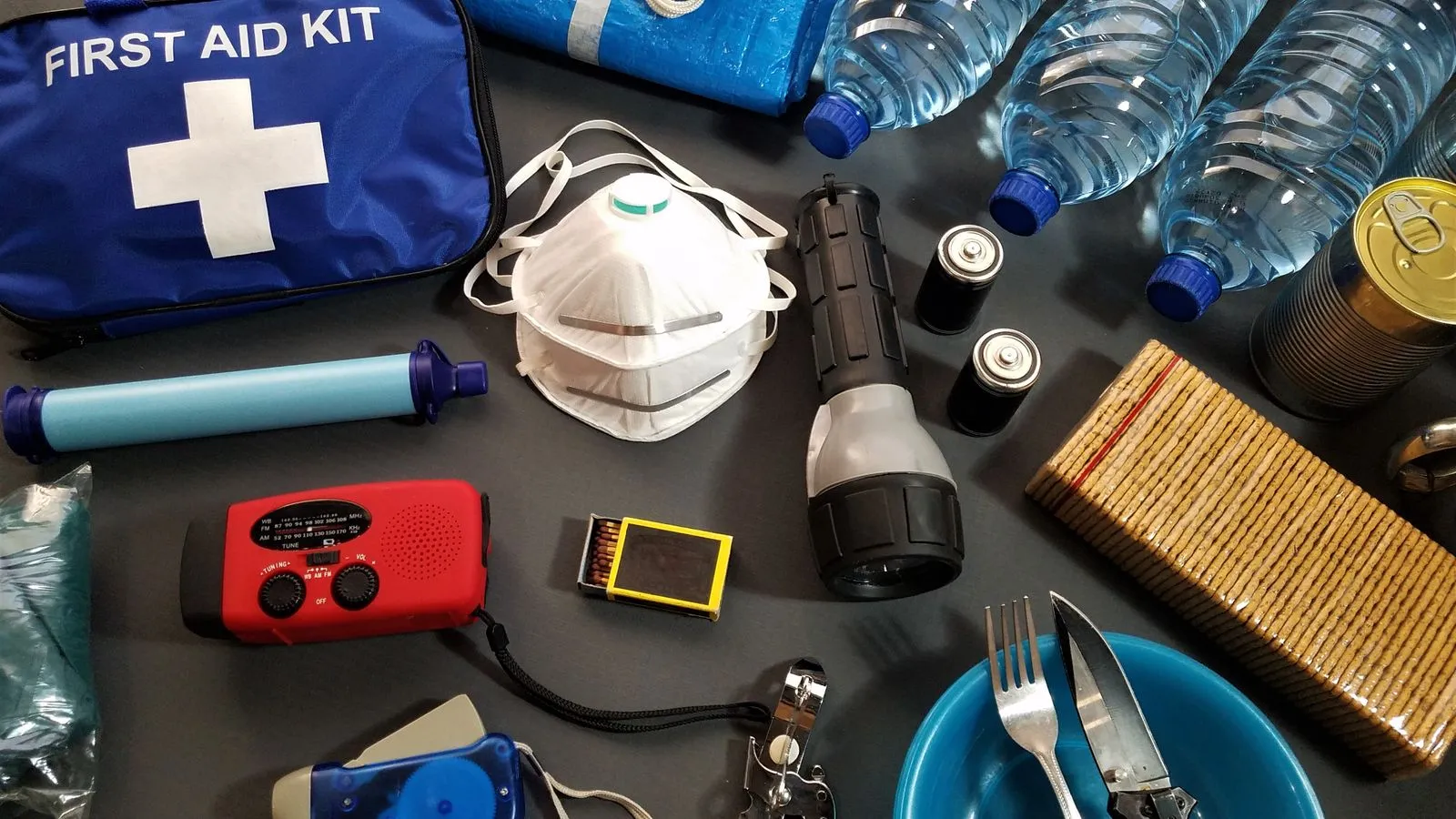 Flat lay of emergency kit items, including first-aid supplies and water bottles