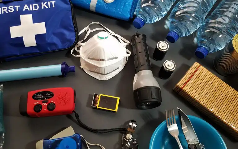Flat lay of emergency kit items, including first-aid supplies and water bottles