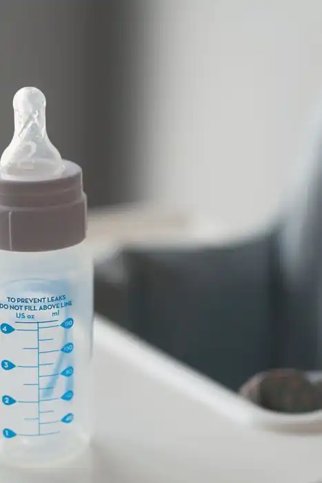 Baby bottle resting on a high-chair tray.