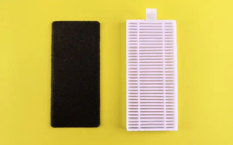 A black foam filter and a white pleated filter are shown against a yellow background.