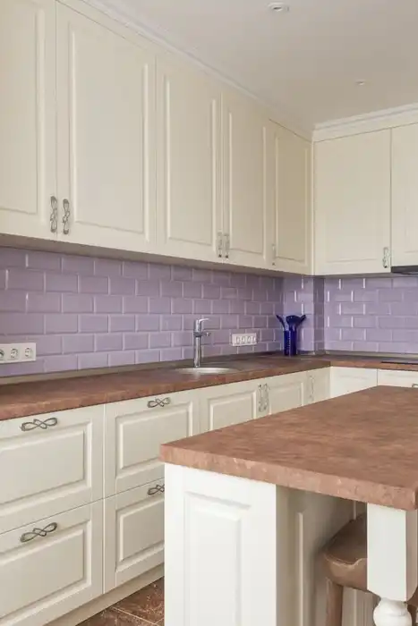 A built-in microwave above an oven in a white kitchen.