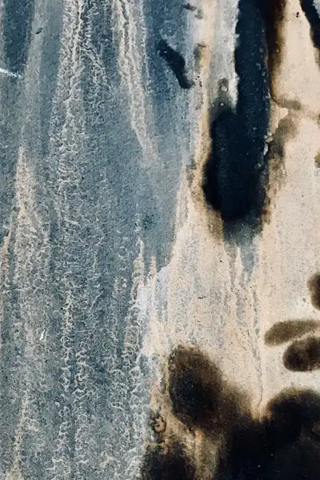 Dark mildew stains and mottled discoloration on a weathered wall surface.