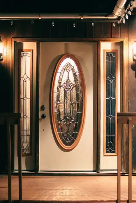 A house entrance and porch are lit at night.