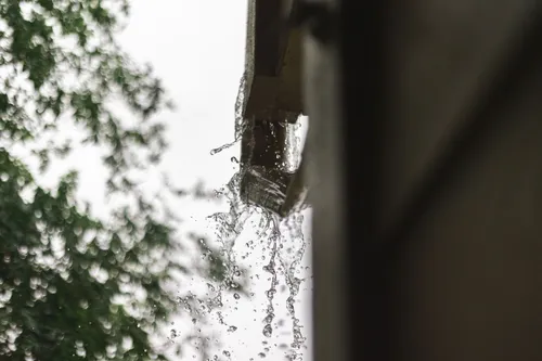 Rainwater spilling from a roof gutter during rainfall