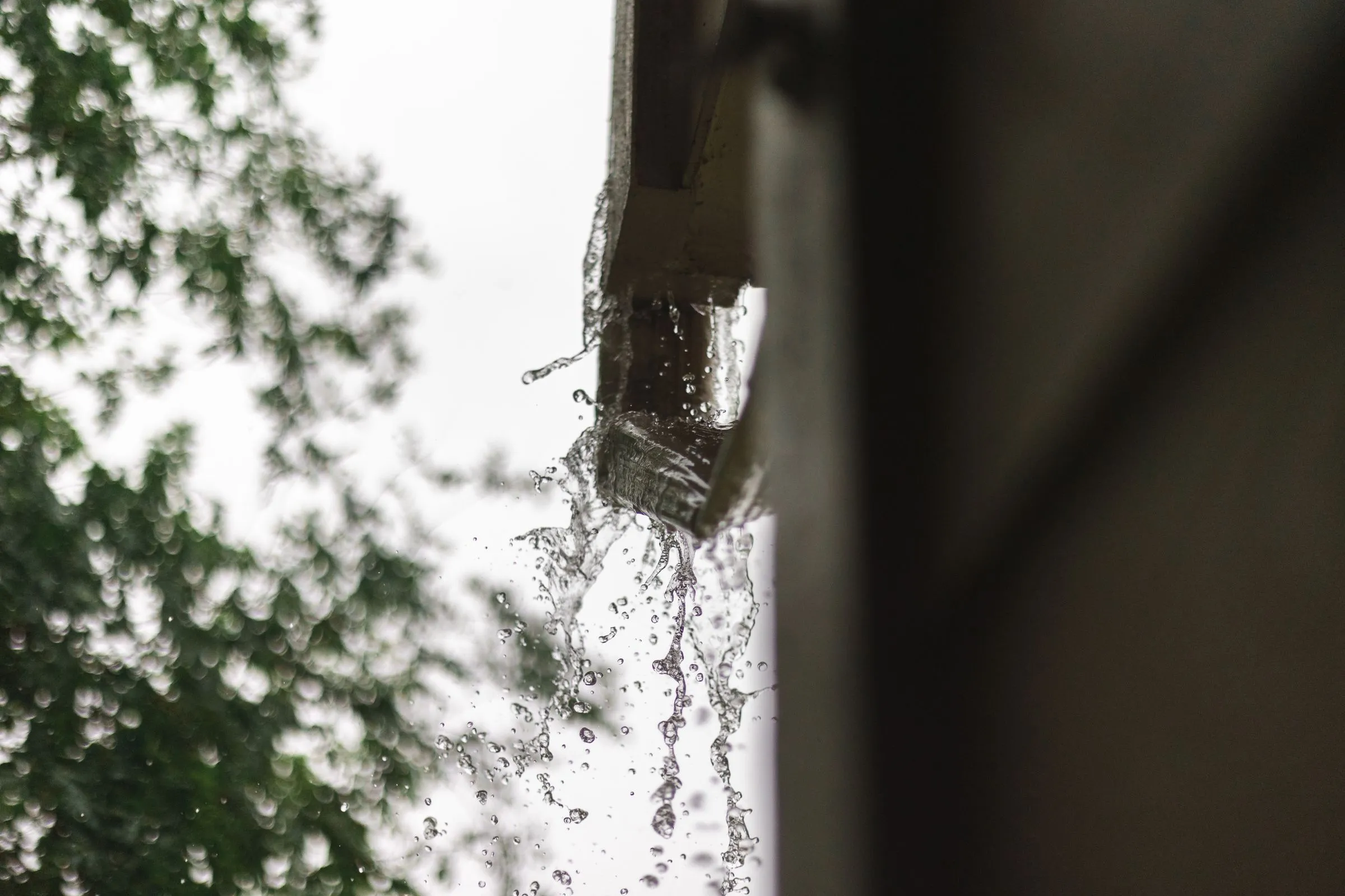 Rainwater spilling from a roof gutter during rainfall