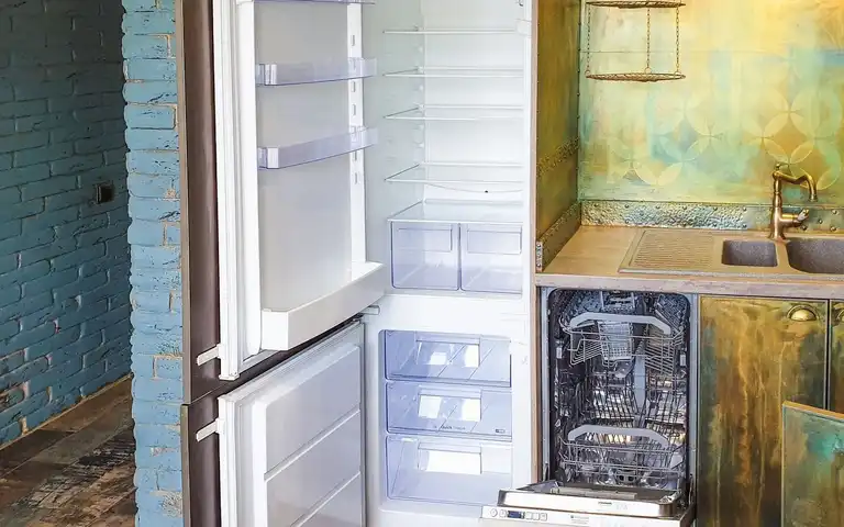 Open refrigerator and dishwasher beside a kitchen sink.