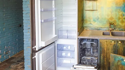 Open refrigerator and dishwasher beside a kitchen sink.
