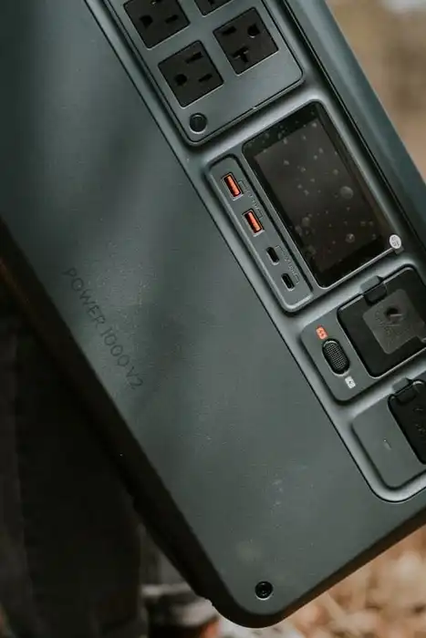 Close view of a portable power station with AC and USB outlets resting on an outdoor surface.