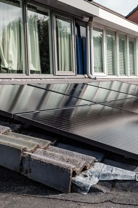 Rows of rooftop solar panels beside a long line of windows.