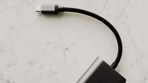 A short braided USB-C cable attached to an adapter on a white surface.