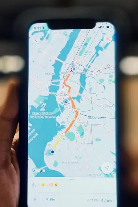 A person holding a smartphone that displays a city map.